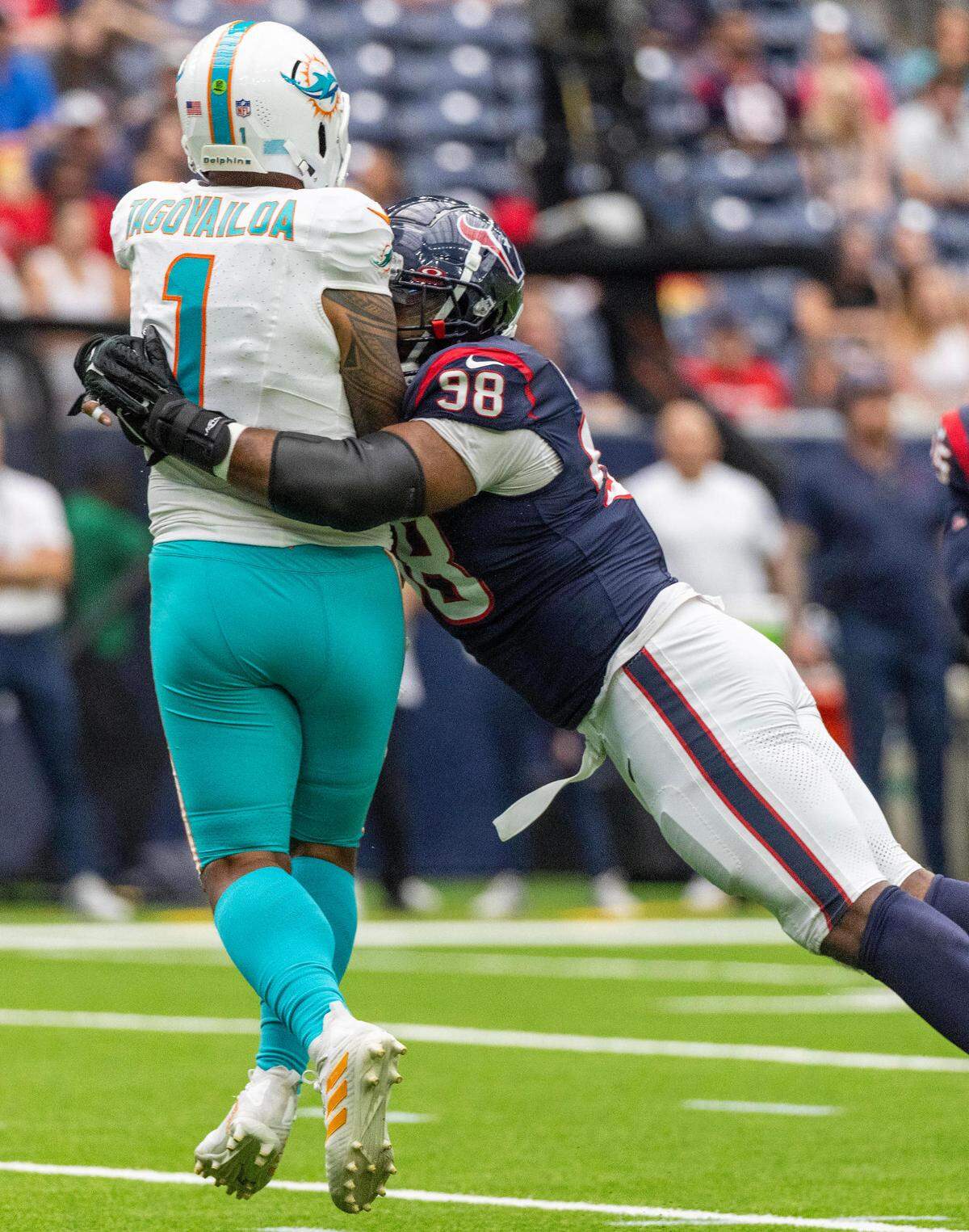 Aug 19, 2023; Houston, Texas, USA; Miami Dolphins quarterback Tua Tagovailoa (1) is hit by Houston Texans defensive tackle Sheldon Rankins (98) after throwing the ball in the first quarter at NRG Stadium. Mandatory Credit: Thomas Shea-USA TODAY Sports