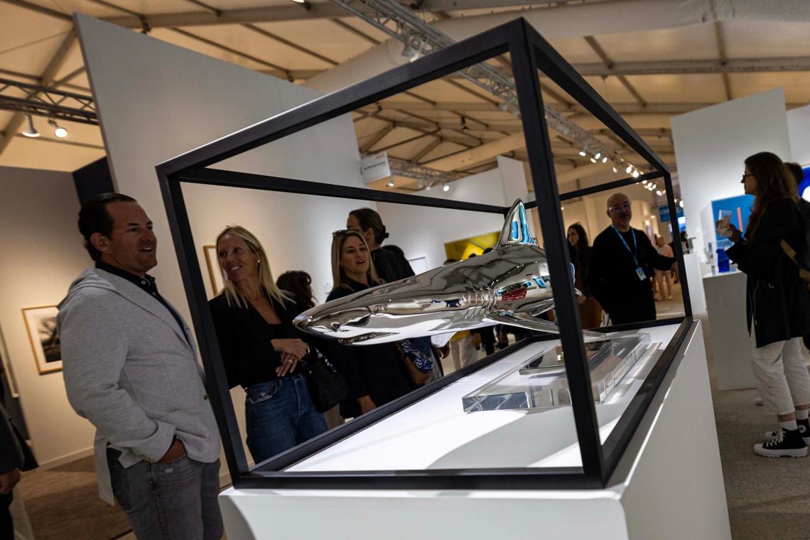 Guests look at a shark shaped sculpture during Art Miami at One Herald Plaza on Tuesday, Dec. 3, 2024, in Miami, Fla.