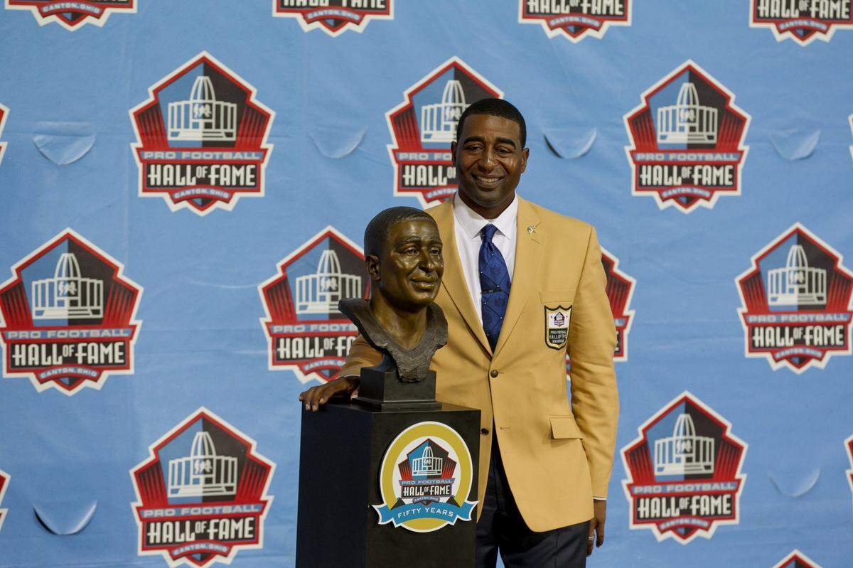 Former Miami Dolphins wide receiver Cris Carter poses with his bust after he was inducted into the NFL Hall of fame during ceremonies at Fawcett Stadium in Canton, Ohio on August 3, 2013.