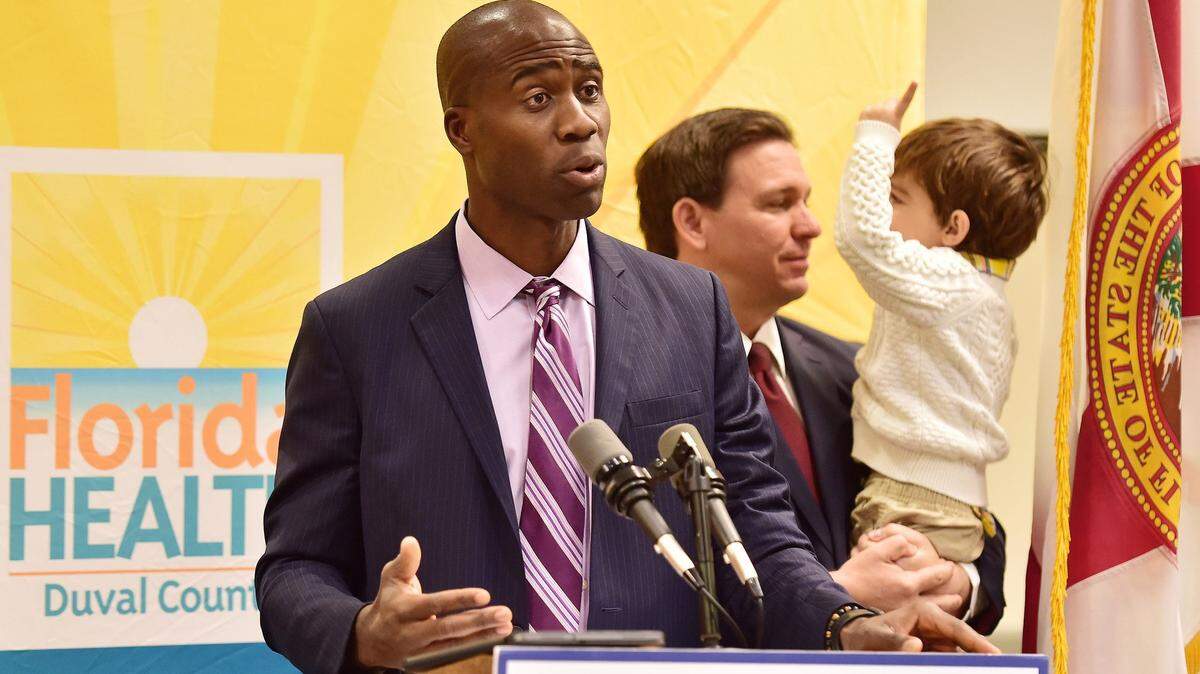 Dr. Joseph Ladapo, the surgeon general of Florida addresses the media during a January 2022 press conference in Jacksonville, with Florida Gov. Ron DeSantis and his son Mason in the background.