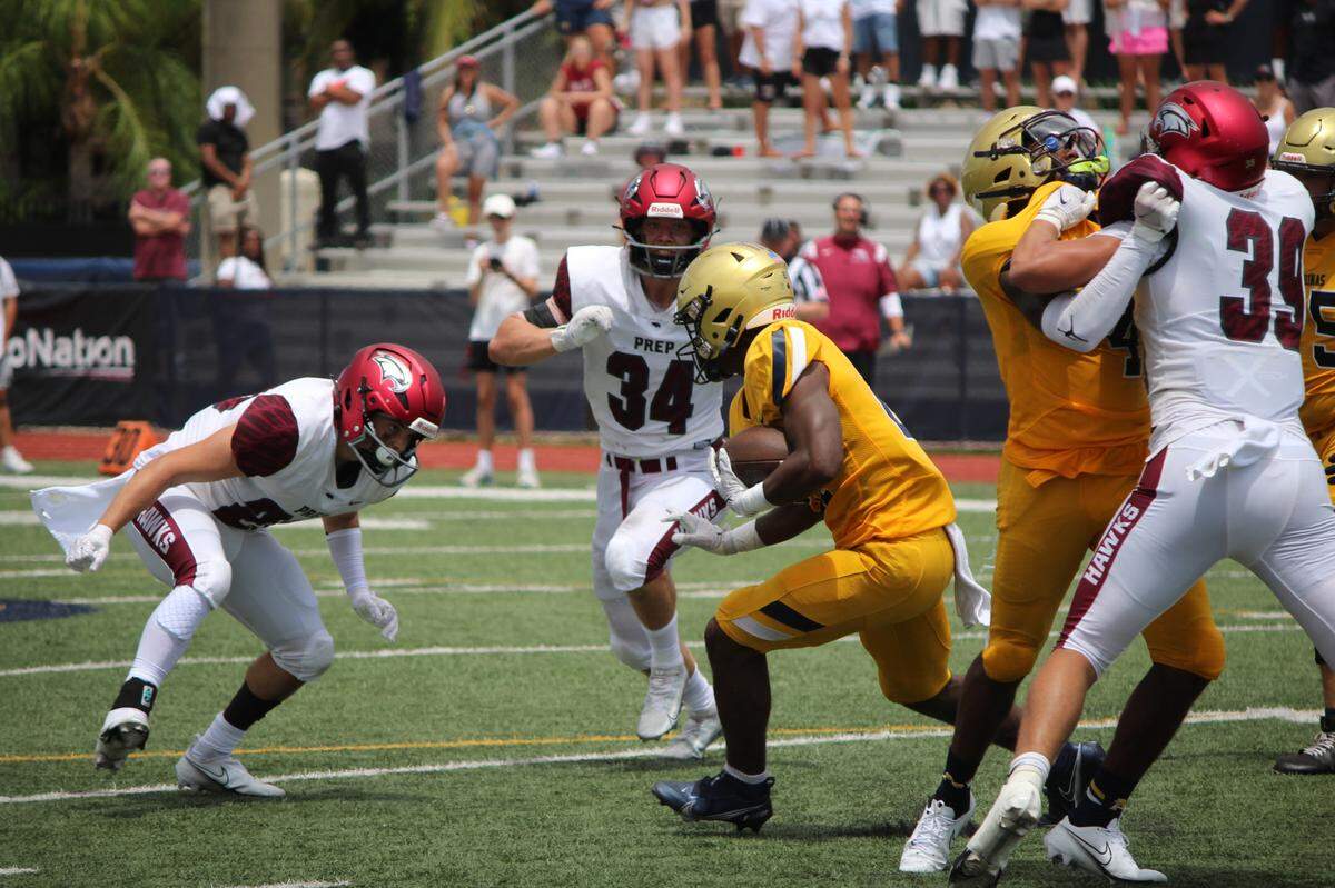 St. Thomas Aquinas running back Jordan Lyle avoids St. John’s Prep defenders for a 6-yard run during the first quarter of the Raiders’ 48-37 win over St. Joseph’s Prep on Saturday afternoon at Aquinas.