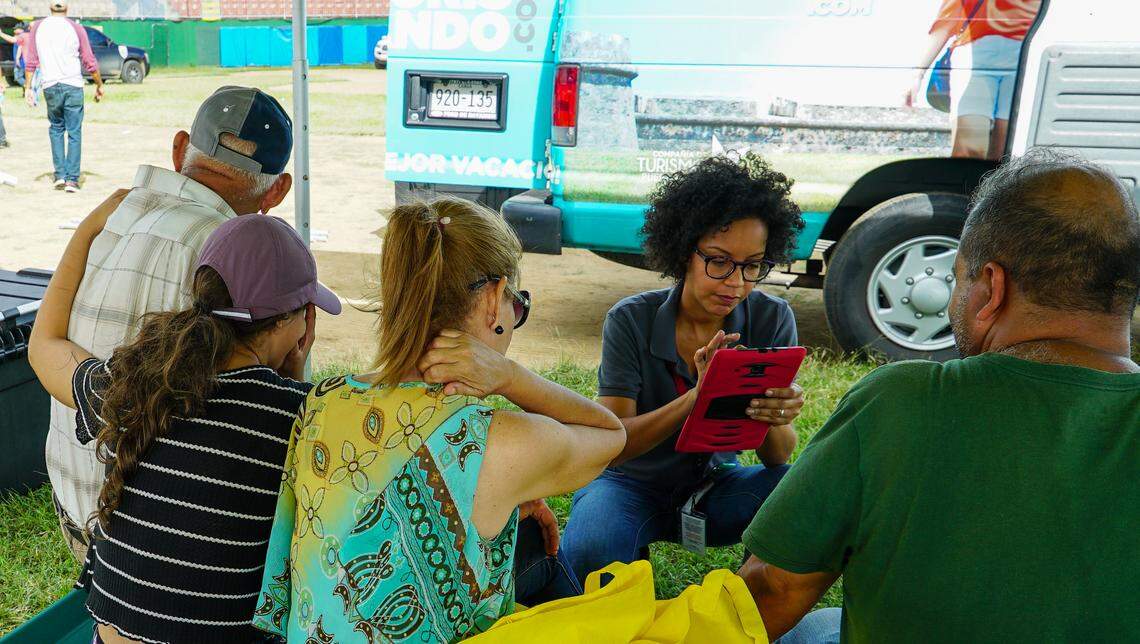 Karla Peña, Mercy Corps’ Puerto Rico Director, interviews a family from Guayanilla. This is one of approximately 300 families who have been staying under tarps in a municipal stadium.