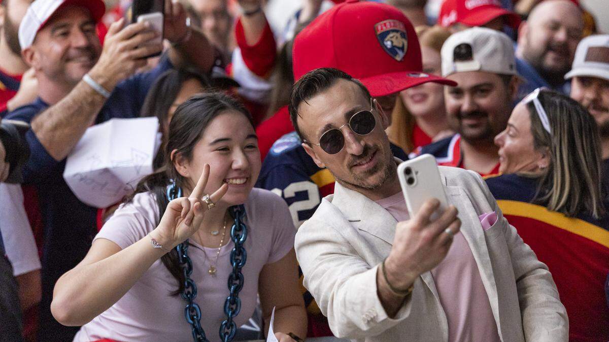 Florida Panthers left wing Brad Marchand (63) takes a selfie with a fan as he arrives to loanDepot for his Winter Classic outdoor hockey game against the New York Rangers on Friday, Jan. 2, 2025, in Miami, Fla.