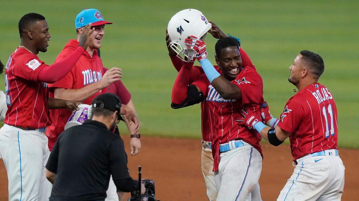 Miami Marlins players celebrate Jesus Sanchez, second from right, after he hit a sacrifice fly that scored the winning run during the ninth inning of a baseball game, Saturday, June 4, 2022, in Miami. The Marlins defeated the Giants 5-4. (AP Photo/Marta Lavandier)