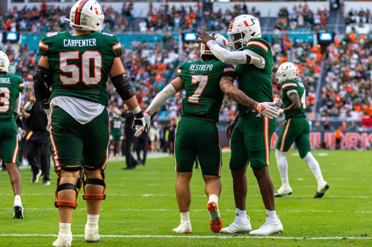 Miami Hurricanes quarterback Cam Ward (1) reacts with wide receiver Xavier Restrepo (7) after the two connected on a touchdown pass during the second half of an ACC football game against the Duke Blue Devils at Hard Rock Stadium on Saturday, Nov. 2, 2024, in Miami Gardens, Fla.