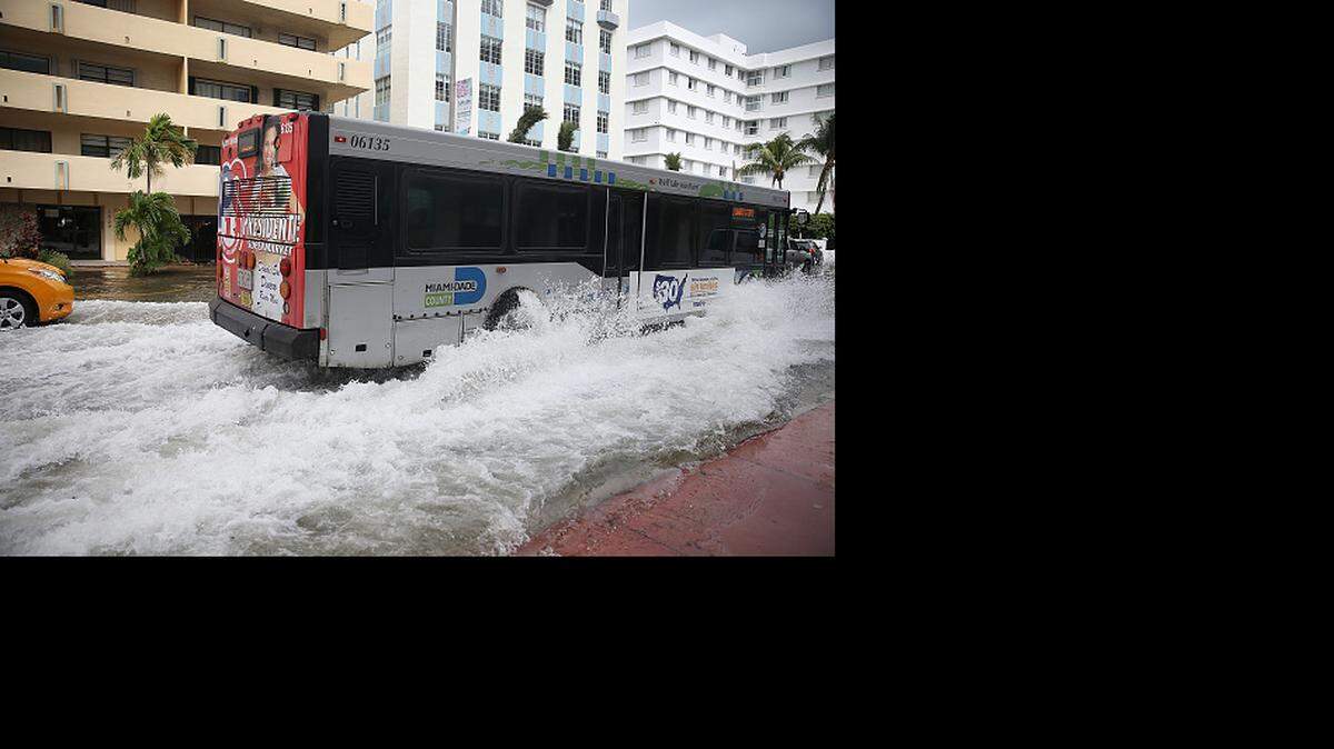 MIAMI BEACH, FL - SEPTEMBER 29: A bus plows through a flooded street that was caused by the combination of the lunar orbit which caused seasonal high tides and what many believe is the rising sea levels due to climate change on September 29, 2015 in Miami Beach, Florida. The City of Miami Beach is in the middle of a five-year, $400 million storm water pump program and other projects that city officials hope will keep the ocean waters from inundating the city as the oceans rise even more in the future. (Photo by Joe Raedle/Getty Images)