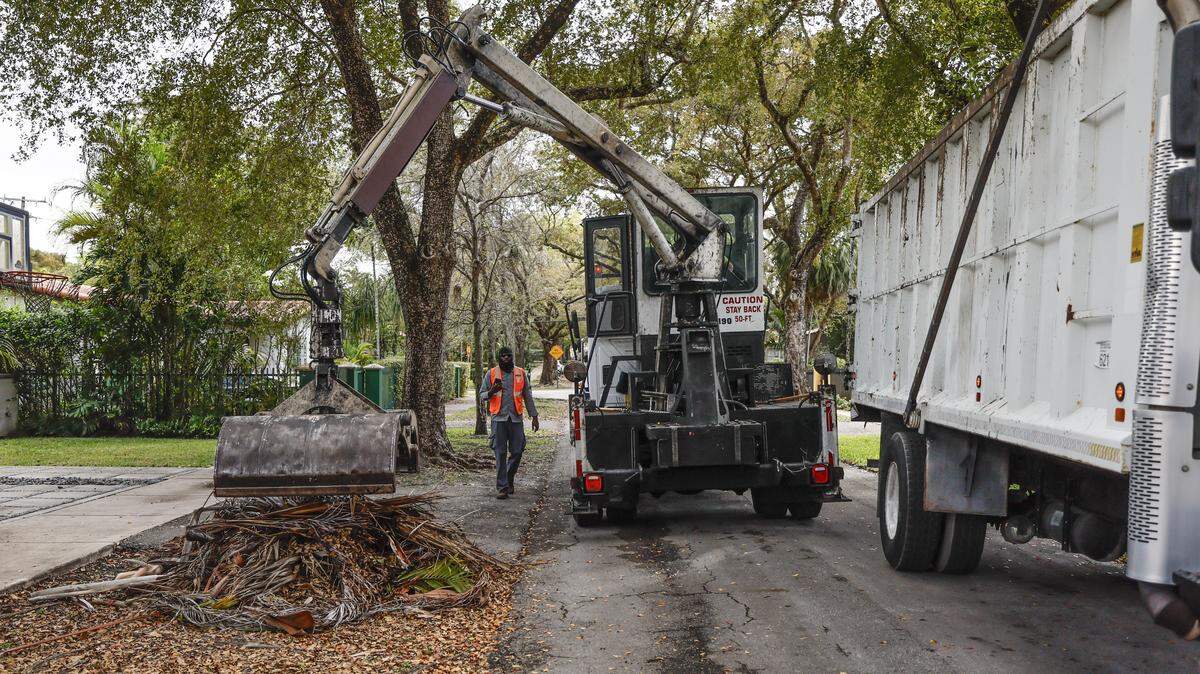Yard debris is collected from the swale in front of a residential property in Coral Gables, Florida, on Friday, March 6, 2026.
