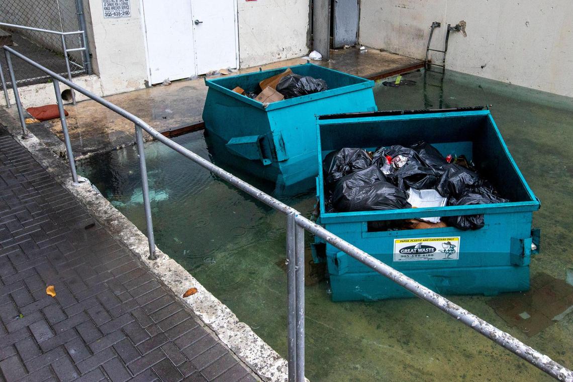 Two garbage dumpsters sit half submerged due to flooding off Brickell Bay Drive in the Brickell neighborhood of Miami, Florida, on Saturday, June 4, 2022.