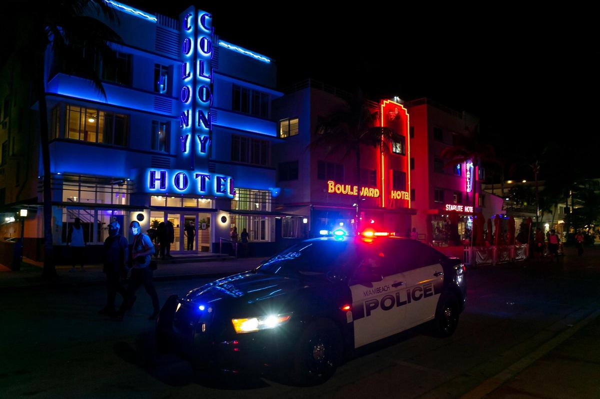 Beach goers head away from Ocean Drive as police enforce the 8 p.m. spring break curfew in Miami Beach on Friday, March 26, 2021.