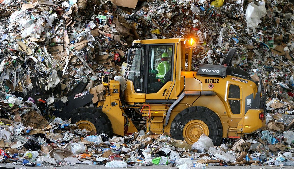 A wheel loader moved a pile of mixed, unsorted recycled materials, including plastic, cardboard, paper, that recently arrived at the Waste Management Recycling Plant at 20701 Pembroke Road in Pembroke Pines, Florida, on Friday, April 8, 2022.