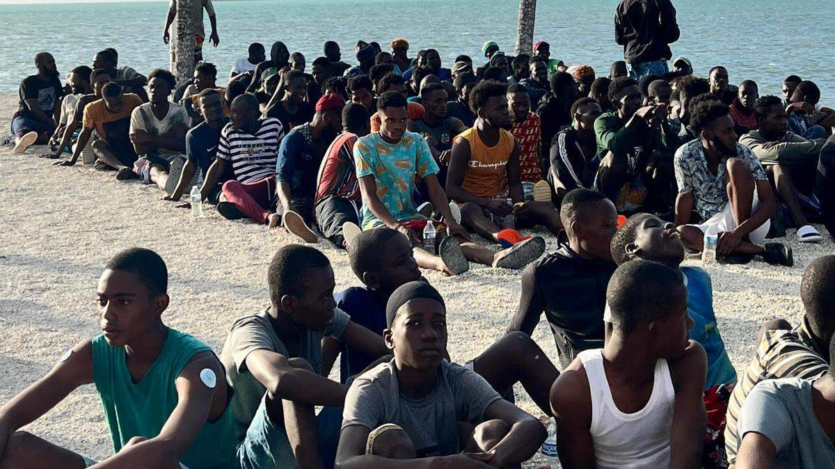 A group of about 100 men from Haiti gather on a beach in the Upper Florida Keys Thursday, Feb. 9, 2023. Authorities say they arrived on an overloaded migrant sailboat. The site is getting more and more unusual following the new policy. PHOTO by David Goodhue/ Miami Herald