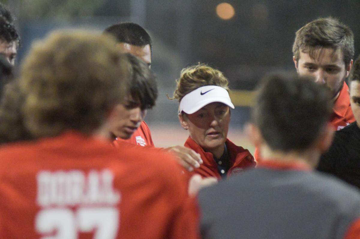 Doral Academy boys’ soccer coach Pamela McDonald talks to her team prior to the Firebirds’ regional final win over Dwyer on Wednesday, Feb. 16, 2022, at Doral Academy.