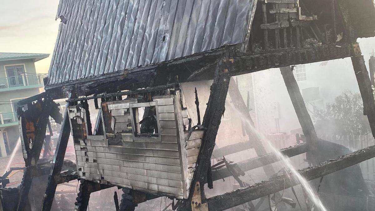 Firefighters house down the remnants of a fire that destroyed a house in Key Largo Wednesday, Sept. 7, 2022.