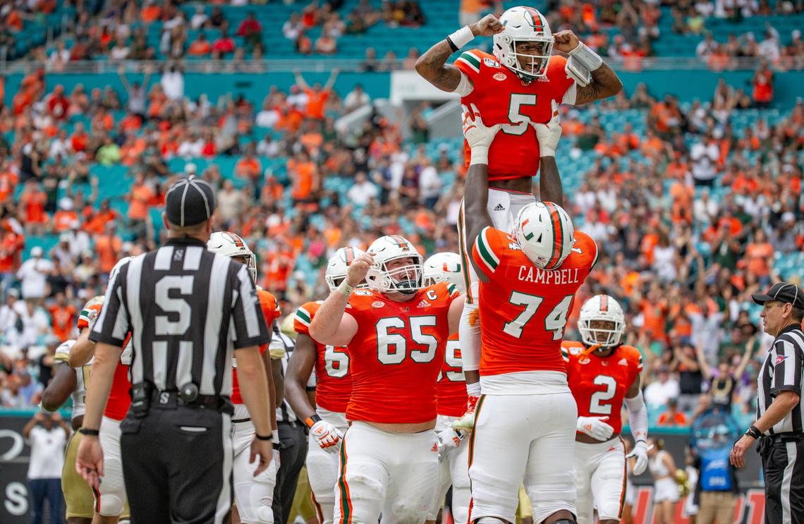 Miami Hurricanes quarterback N’Kosi Perry (5) is lifted by Miami Hurricanes offensive lineman John Campbell Jr. (74) as they celebrate scoring in the first quarter as the University of Miami hosts the Georgia Tech Yellow Jackets at Hard Rock Stadium in Miami Gardens on Saturday, October 19, 2019.