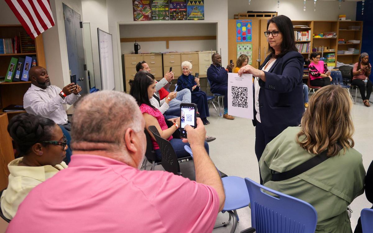 Attendees scan a QR code using their smartphones to download an app to be used during a breakout session as Broward County Public Schools held the second of three town halls to discuss with the community the possibility of closing schools in 2025.