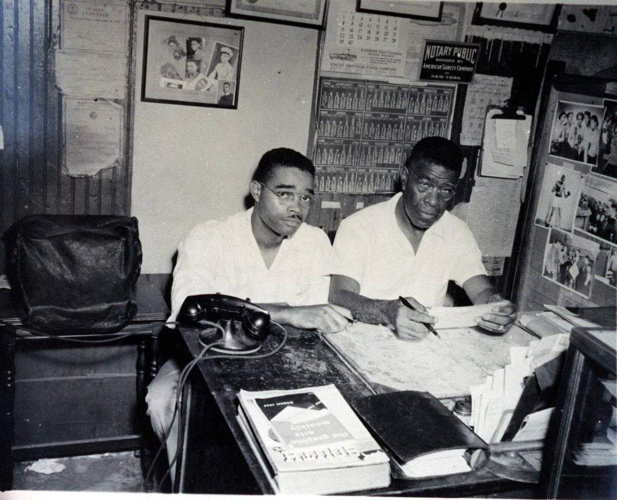Garth Reeves Sr., left, the longtime publisher of the Miami Times, and his father, Henry E. S. Reeves, in their Overtown newspaper office, circa 1950s. Henry founded the Miami Times in 1923, initially printing it one page at a time on a small hand press in his Miami home.