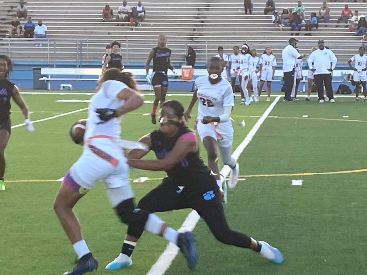Miami Palmetto’s Ashley Alvarado pulls the flag from Homestead’s Kimani Graham during the GMAC flag football championship on Friday night at Traz Powell Stadium in Miami, Fla.