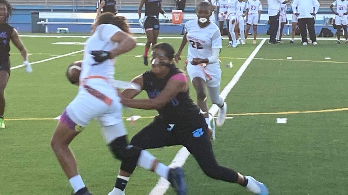 Miami Palmetto’s Ashley Alvarado pulls the flag from Homestead’s Kimani Graham during the GMAC flag football championship on Friday night at Traz Powell Stadium in Miami, Fla.