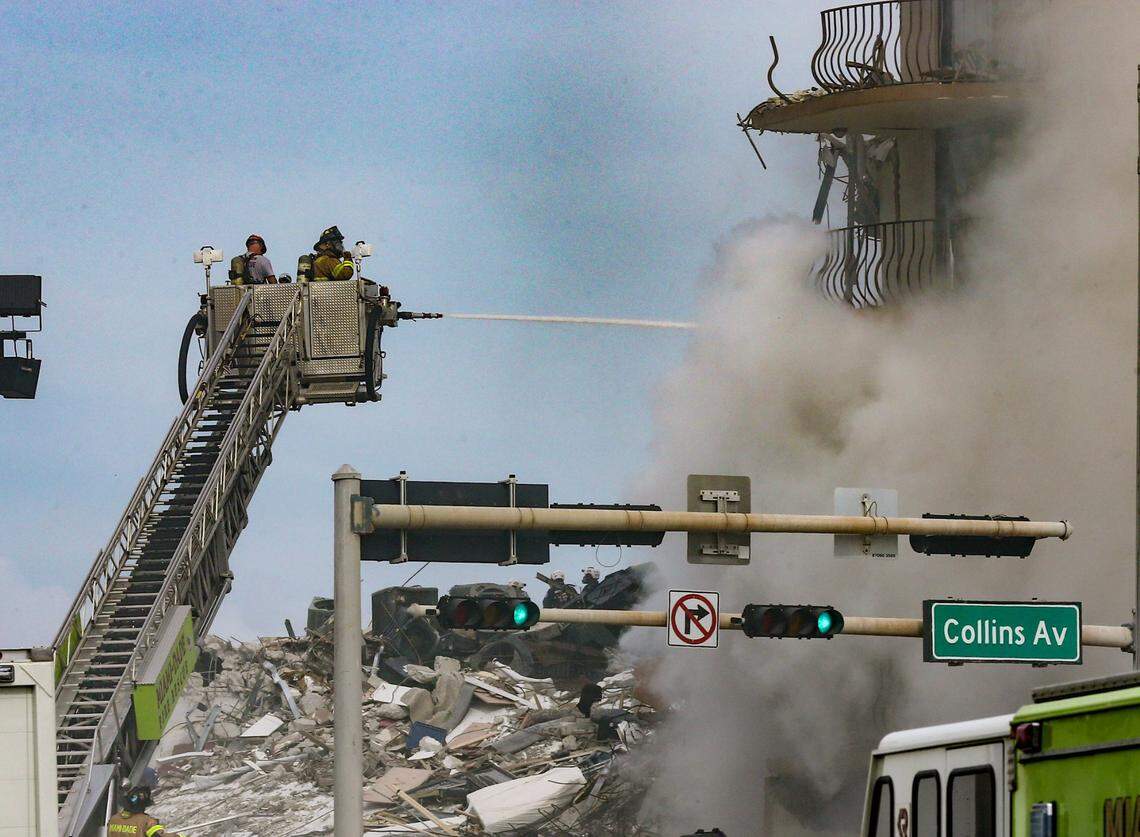 Firefighters battle a blaze as rescue workers search debris at the 12-story oceanfront condo, Champlain Towers South, on Friday, June 25, 2021. The condo partially collapsed early Thursday morning in the town of Surfside