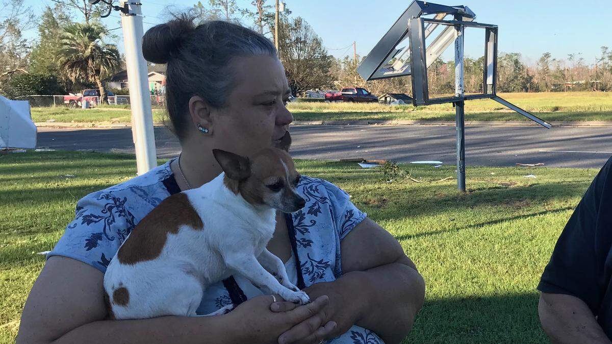 Rebecca Baldwin holds her dog Mini Pearl Friday morning outside the church she and her husband evacuated to after Hurricane Michael wrecked their Marianna home.