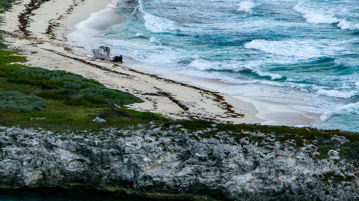 An abandoned vessel on a beach on a deserted island is seen during a U.S. Coast Guard reconnaissance flight Friday, April 22, over the Florida Straits and the Bahamas.