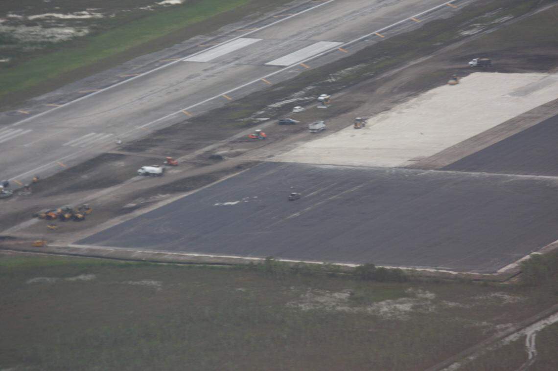 An aerial image of the site shows the footprint of the site expanded with fill and asphalt.