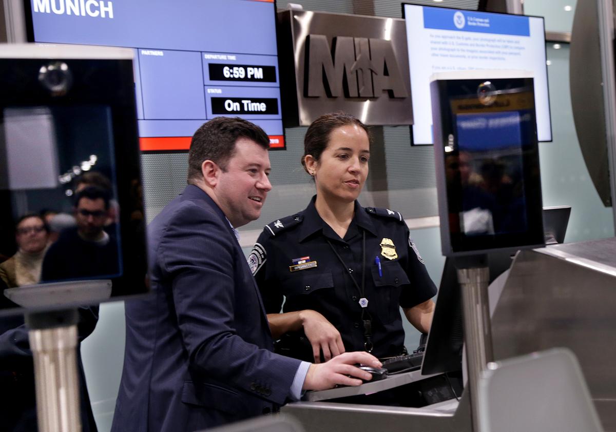 James P. Sgueglia, gerente de Lufthansa, y la agente Jessica Brigantty, de Aduanas y Protección Fronteriza, verifican el sistema de embarque antes que los pasajeros del vuelo 461 con destino a Munich, Alemania, partan del Aeropuerto Internacional de Miami.