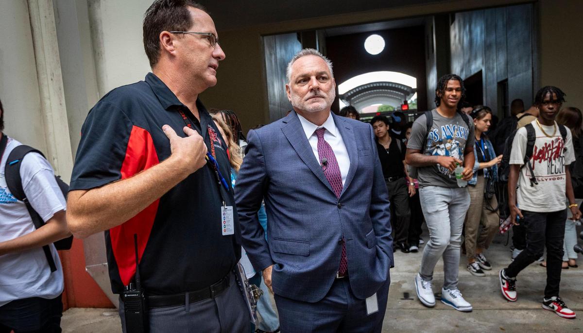 Coconut Creek, 21 de agosto de 2023 - El superintendente de las Escuelas de Broward, Peter Licata, en el centro, habla con el director de la Secundaria Monarch, James Cecil, a la izquierda, mientras estudiantes entran en el edificio para el primer día de clases en el Condado Broward.