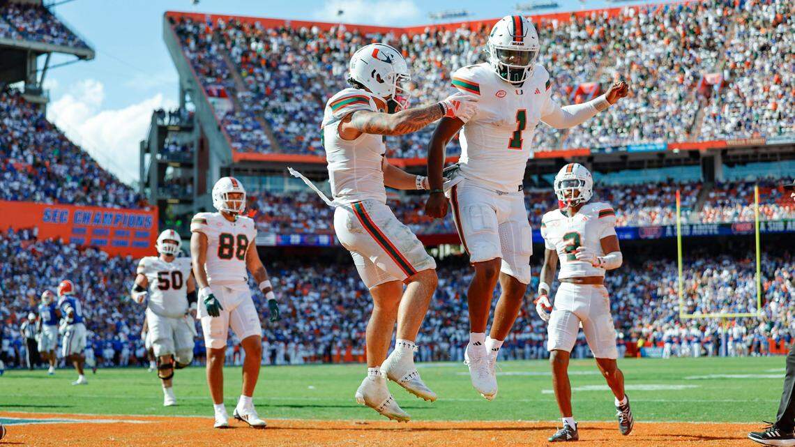 Miami Hurricanes wide receiver Xavier Restrepo (7) and quarterback Cam Ward (1) celebrate in the end zone after Restrepo scores on a pass by Ward during the second quarter of an NCAA college football game at Ben Hill Griffin Stadium in Gainesville, Florida, on Saturday, August 31, 2024.