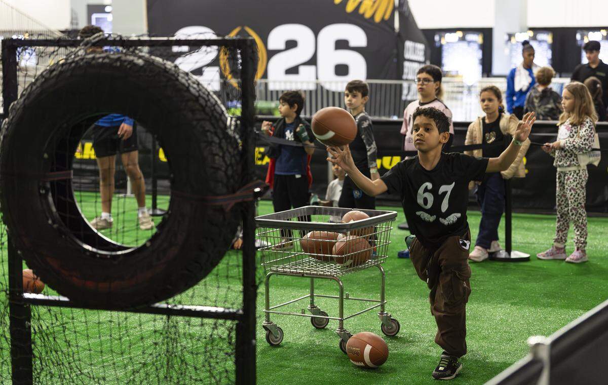 Noah Rosier, 8, throws a football as he visits the Playoff Fan Central at the Miami Beach Convention Center on Friday, Jan. 16, 2025, in Miami Beach, Fla. Fans can visit the event ahead of the College Football Playoff National Championship Game between the Miami Hurricanes and the Indiana Hoosiers and enjoy a variety of family-friendly interactive experiences.