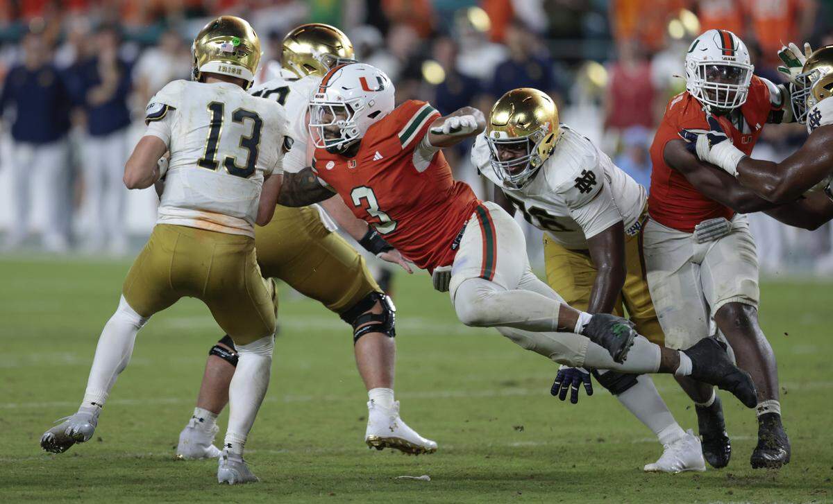 Miami Hurricanes defensive lineman Akheem Mesidor (3) sacks Notre Dame Fighting Irish quarterback CJ Carr (13) in the second half of an NCAA football game at Hard Rock Stadium in Miami Gardens, Florida, on Sunday, August 31, 2025.