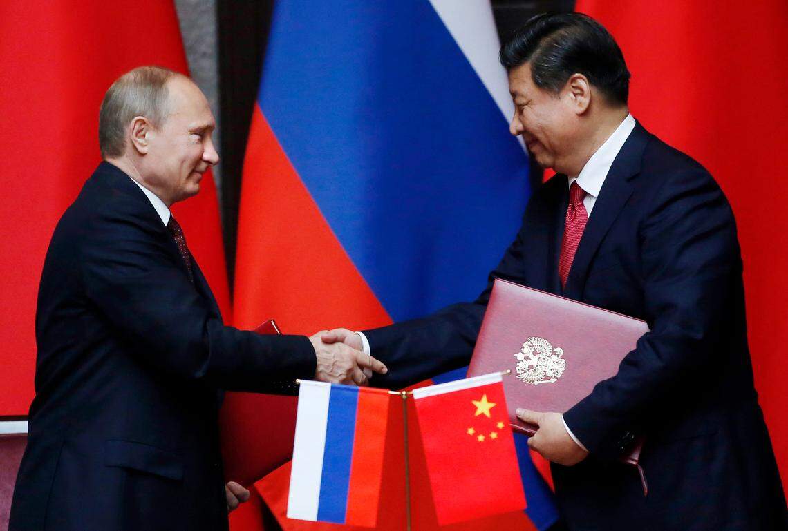 Russia’s President Vladimir Putin, left, and China’s President Xi Jinping shake hands after signing an agreement during a bilateral meeting at the Xijiao State Guesthouse ahead of the fourth Conference on Interaction and Confidence Building Measures in Asia (CICA) summit, in Shanghai, China Tuesday, May 20, 2014. (AP Photo/Carlos Barria, Pool)