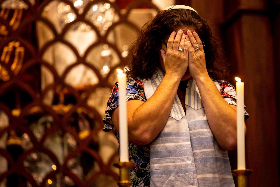 Senior Rabbi Amy Morrison covers her eyes while reciting the blessing over the Shabbat candles during service at Temple Israel of Greater Miami in Miami, Florida, on Friday, March 11, 2022.