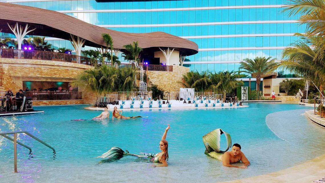 Mermaids and mermen lounge in one of the Hard Rock pools at the grand opening party.