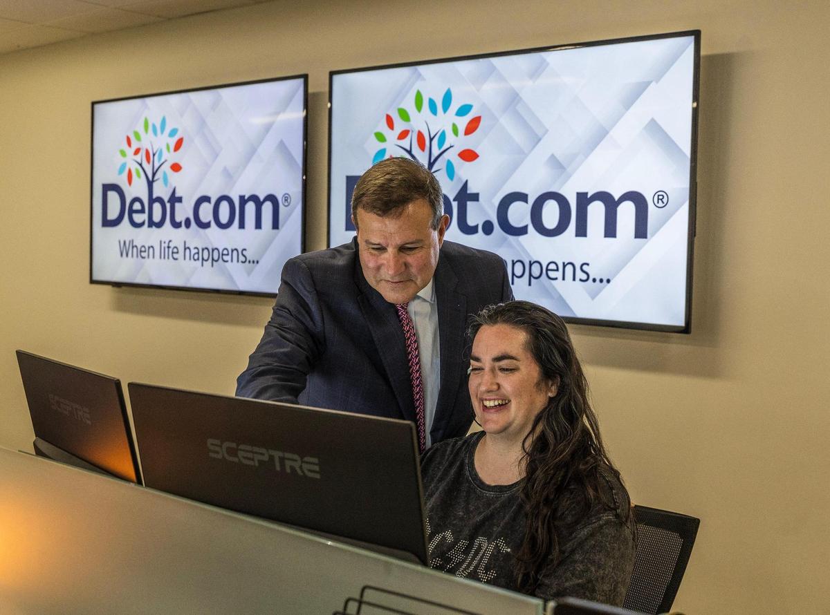 Howard Dvorkin, the founder of Debt.com, shares a moment with Taylor Sica, media manager, in his office in Davie, Florida, on Thursday, March 13, 2025.