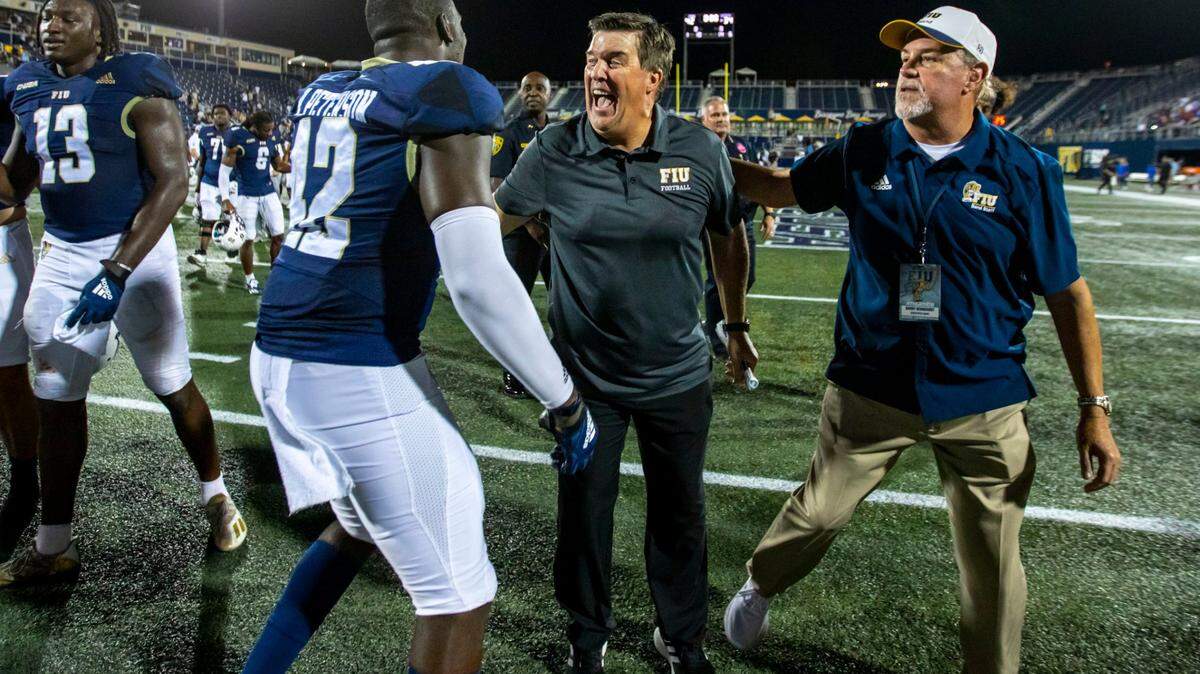 Florida International University head coach Mike MacIntyre reacts with linebacker Reggie Peterson (42) after defeating Louisiana Tech University 42-34 during double-overtime of an NCAA Conference USA football game at Riccardo Silva Stadium in Miami, Florida, on Friday, October 28, 2022.