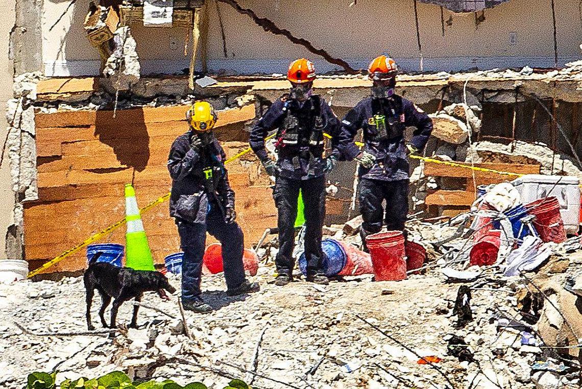 Rescuers and a rescue dog are seen on the rubble as the search and rescue mission continues at the site of the Champlain Towers South nine days after the condo building collapsed on Friday, July 2, 2021.