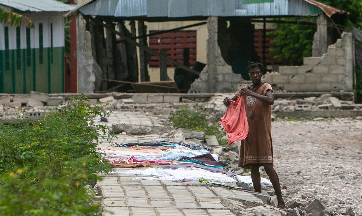 A woman lays her clothes out to dry on a collapsed wall in the town of Maniche on Monday, Aug. 23, 2021. The town in Haiti’s southwest was destroyed by the earthquake on Aug. 14.