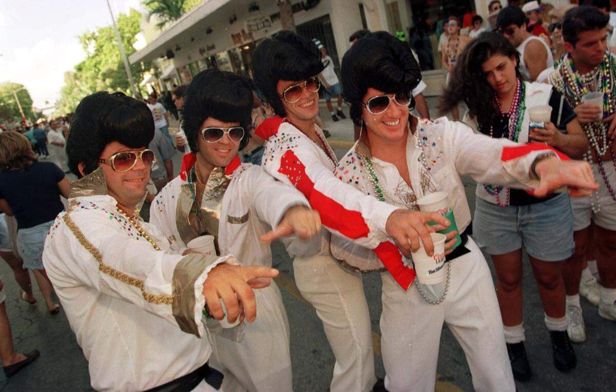 A group of roaming Elvis impersonators pose for pictures for Fantasy Fest partygoers on Duval Street.