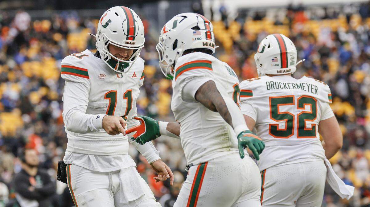 Miami Hurricanes CharMar Brown (9) celebrates with and quarterback Carson Beck (11) after scoring on a 9-yard pass recception in the second half of their NCAA football game at Acrisure Stadium in Pittsburgh, PA, on Saturday, November 29, 2025.