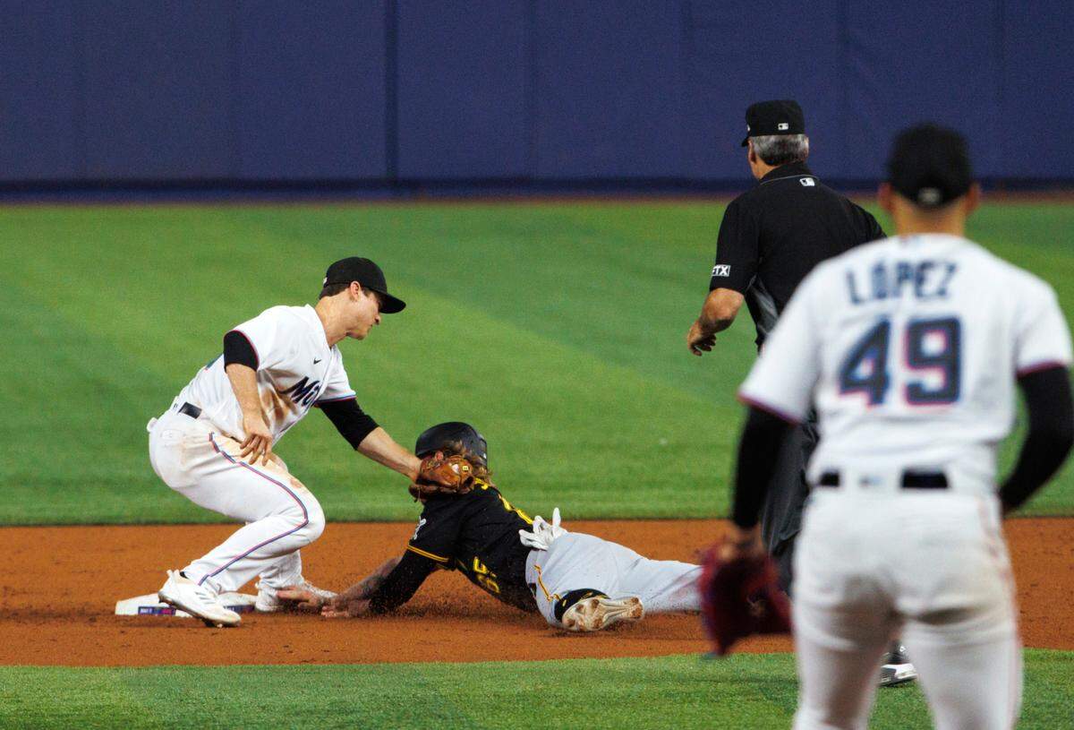 Pittsburgh Pirates left fielder Jack Suwinski (65) slides into second base as Miami Marlins shortstop Joey Wendle (18) apply a tag for an out during the fifth inning of a baseball game at LoanDepot Park on Wednesday, July 13, 2022 in Miami, Florida.