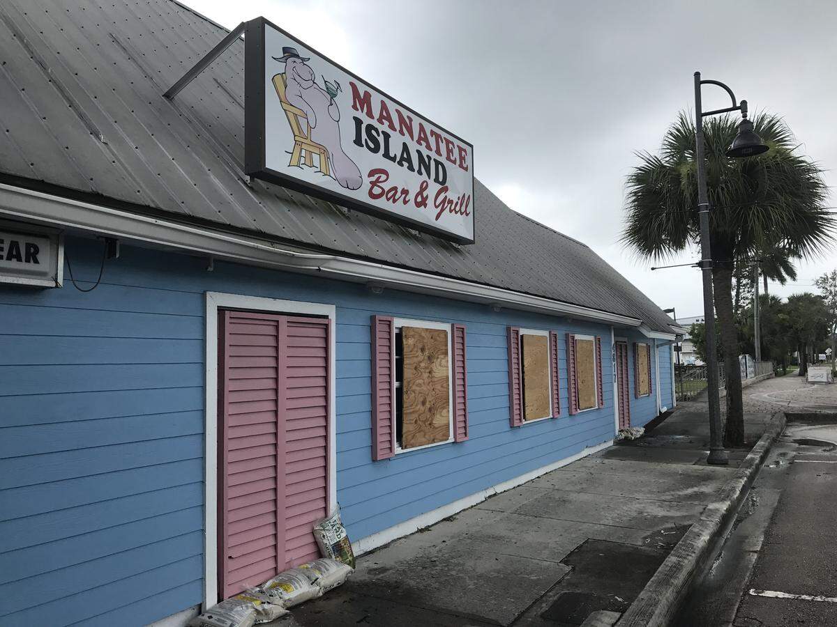 Plywood covers the windows of the Manatee Island Bar and Grill in Port Salerno, a small waterfront town in unincorporated Martin County.