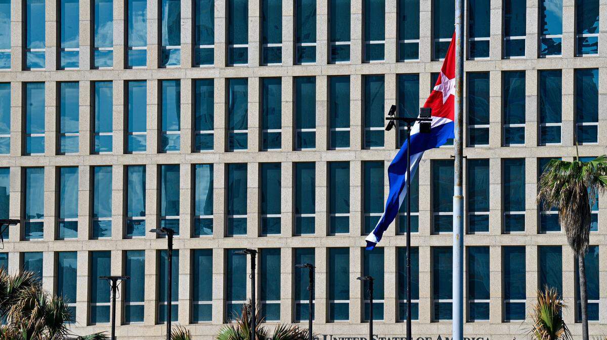 La bandera cubana ondea a media asta frente a la Embajada de Estados Unidos en La Habana, en medio de la suspensión de servicios consulares y entrevistas de visa a cubanos. Cuba decretó luto nacional tras la muerte de 32 ciudadanos durante la operación militar de EEUU que culminó con la captura de Nicolás Maduro en Caracas. (Foto de Adalberto ROQUE / AFP vía Getty Images)