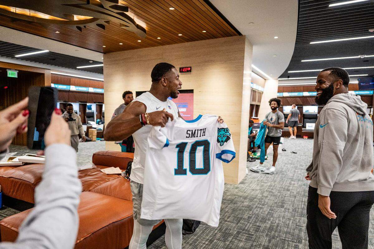 Miami Dolphins tight end Jonnu Smith (left) holds up his high school football jersey that inside linebacker Anthony Walker Jr. (right) gifted him. Walker gifted every player on the Dolphins as well as a few coaches their high school jersey.