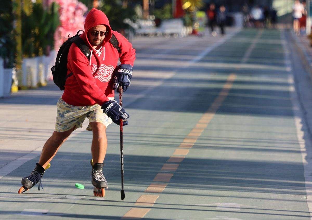 A hockey enthusiast takes advantage of the cool weather and skates with a hockey puck southbound on Ocean Drive as cooler temperatures swept through Miami-Dade. An arctic blast moved into South Florida late Tuesday, bringing a sharp overnight temperature drop. Visitors and residents alike promenade in hoodies, sweaters, coats, and other cold-weather gear on Ocean Drive as breezy north winds made it feel colder through New Year's Eve and New Year's Day. Morning lows were in the upper 40s to low 50s, with daytime highs near the low 70s on Wednesday, December 31, 2025, in Miami Beach, Florida.