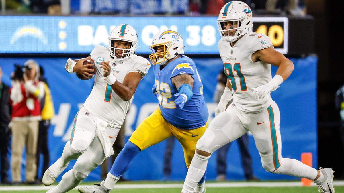 Miami Dolphins quarterback Tua Tagovailoa (1) is chased out of the pocket by Los Angeles Chargers defensive end Joe Gaziano (92) in the third quarter at SoFi Stadium in Inglewood, California on Sunday, December 11, 2022.