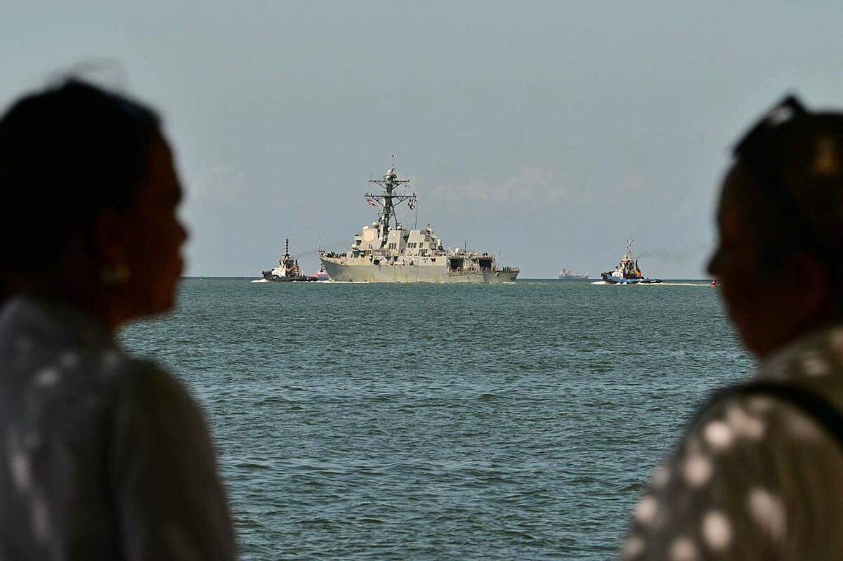 People watch the USS Gravely, a US Navy warship, departing the Port of Spain on October 30, 2025. The US warship arrived in Trinidad and Tobago on October 26, 2025, for joint exercises near the coast of Venezuela, as Washington ratcheted up pressure on drug traffickers and Venezuelan leader Nicolas Maduro. (Photo by MARTIN BERNETTI/AFP via Getty Images)
