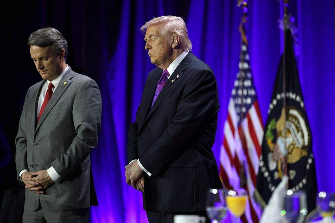 WASHINGTON, DC - FEBRUARY 05:  U.S. President Donald Trump (R) bows his head in prayer during the 74th annual National Prayer Breakfast at the Washington Hilton on February 5, 2026 in Washington, DC. President Trump is joined by bipartisan Congressional members, business, and religious leaders to pray for the nation. (Photo by Alex Wong/Getty Images)