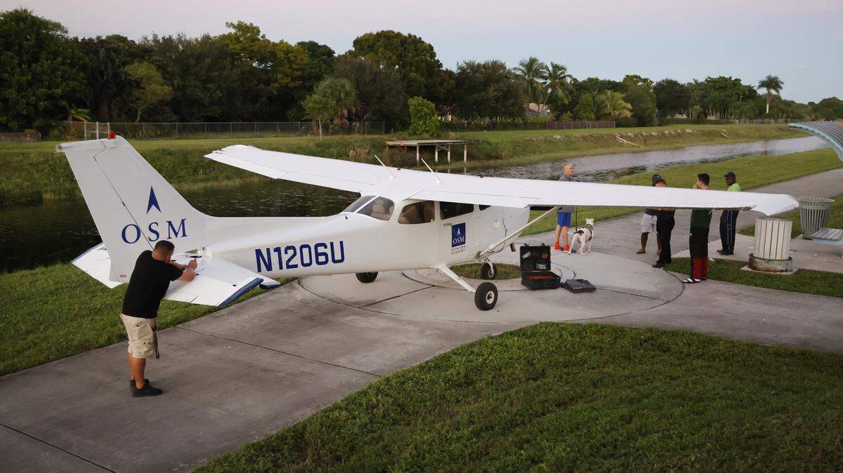 A man works on fixing a small plane that made an emergency landing near the Cypress Creek Canal in North Lauderdale on Monday, Oct. 13, 2025. (Carline Jean/South Florida Sun Sentinel)