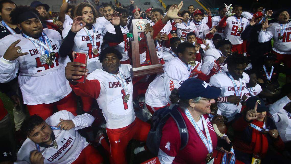 Champagnat Catholic players and coaches pose for a team photo with the trophy after their FHSAA Class 2A Football State Championship against Lakeland Victory Christian Thursday, Dec.. 5, 2019 in Tallahassee, Fla. Champagnat Catholic won 35-14.